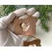 Photo of Copper I Love Oregon Ornament with Heart shape cutout in the middle and an Oregon Sunstone gemstone hanging inside the heart cutout, held in my hand for size reference